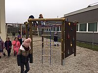 Schüler klettern auf einen Spielturm