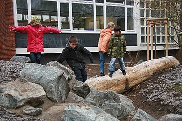 Kinder balancieren auf Wasserläufen im Hof