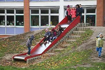 Kinder rutschen eine Rutsche im Freien hinunter